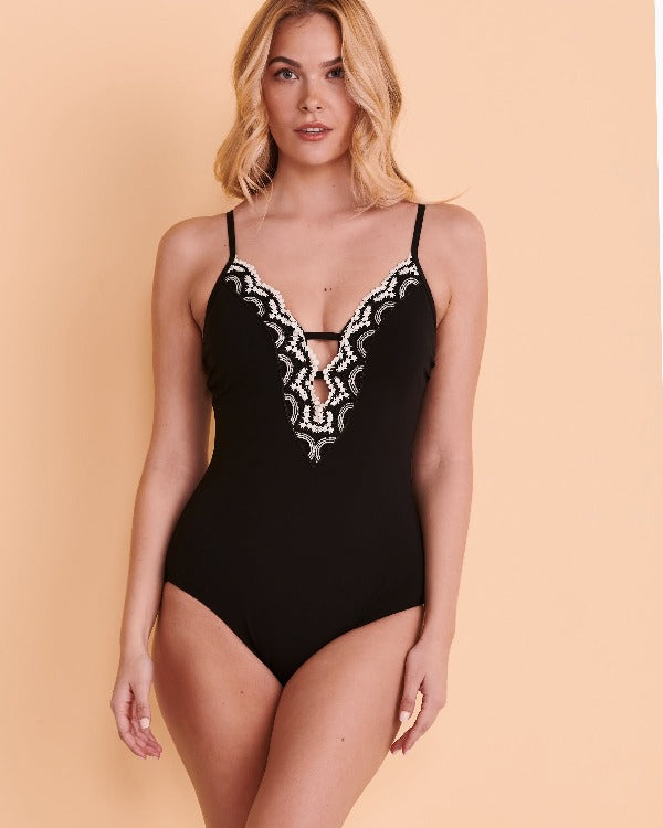 Take a plunge in this gorgeous and chic bust enhancing one piece swimsuit. This suit features a spaghetti strap with a deep plunge neckline detailed with black and white lace. The built in soft cups lift and separate while the fitted bodice trims the waist. You'll find a higher cut leg-line with fuller seat coverage completes this glamorous look. Photos by bikini village
