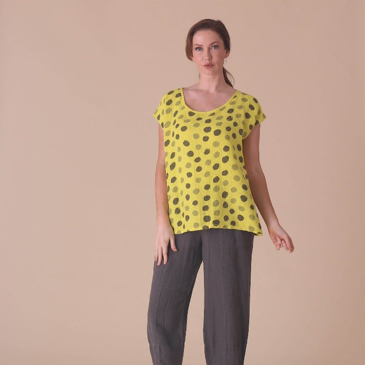 This beautiful linen t-shirt with scoop neck and polka dots in a sunny yellow  features short cap sleeves and a longer fit below the hips. Perfect for any dinner or a relaxing read by the pool. 