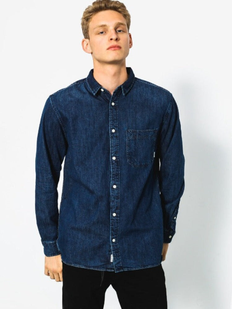A classic denim design with a modern longer length fit, makes this shirt a timeless yet versatile choice.  This long sleeve shirt is made of lightweight denim and offers a modern fit - the length of a regular fit but with a slimmer cut. It also features a single chest pocket and scallop hem. Constructed of 100% cotton, the Quiksilver Denim Long Sleeve Shirt is sure to be a reliable wardrobe essential.     EQYWT03553