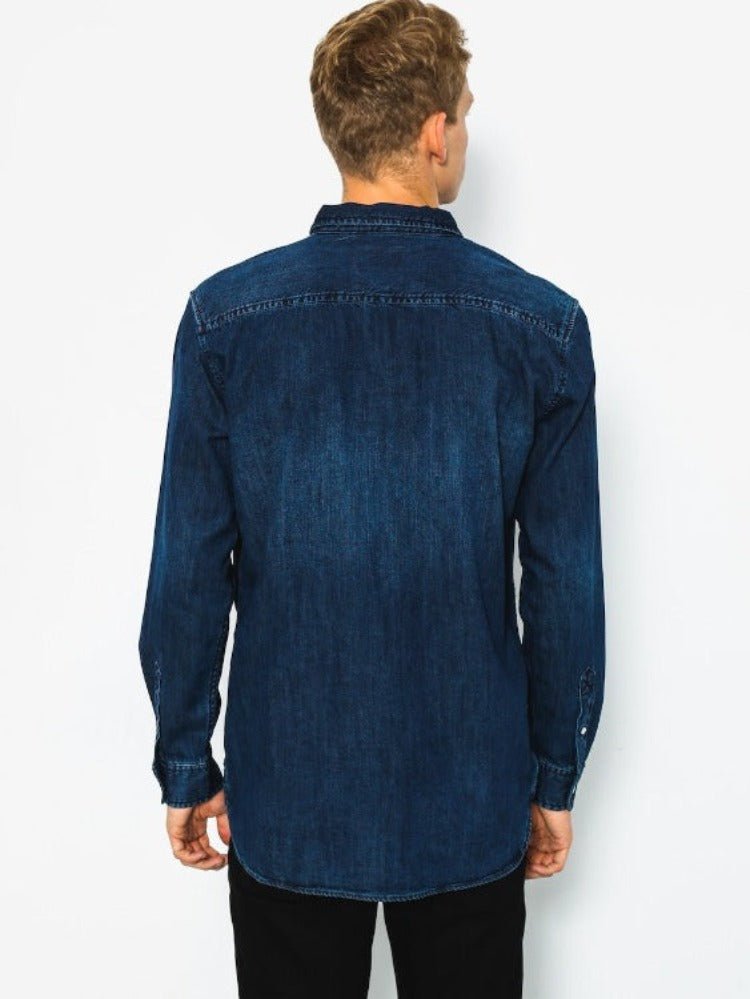 A classic denim design with a modern longer length fit, makes this shirt a timeless yet versatile choice.  This long sleeve shirt is made of lightweight denim and offers a modern fit - the length of a regular fit but with a slimmer cut. It also features a single chest pocket and scallop hem. Constructed of 100% cotton, the Quiksilver Denim Long Sleeve Shirt is sure to be a reliable wardrobe essential.     EQYWT03553