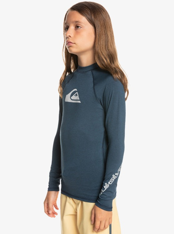 This All Time Boys Long Sleeve Rashguard is the perfect companion for outdoor activities. With UPF 50+ protection, you can rest assured that your little one is safe from the sun's rays, allowing them to move and explore without worry. The recycled yarn fabric is lightweight, providing optimal comfort and a snug fit, while also promoting sustainability. Additionally, the moisture-wicking properties will keep your child cool and dry, making this essential part of every adventurer's wardrobe.        EQBWR03128