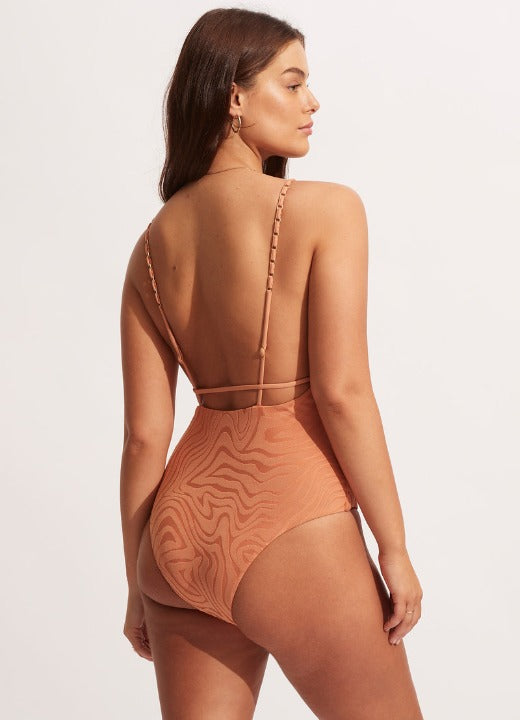Seafolly Second wave v-neck one piece ﻿Cheeky and oh so stunning this elegant minimal one piece has all our mod ladies gasping! It's textured and in a stunning copper pastel guaranteed to make you glow in the coastal sun. Gold hardware details in straps also make this so luxurious.  Cut Away Scoop Back Removable Cups for Shape and Support Internal Shelf Bra for Bust Support Adjustable Straps for Fit Versatility High Legline to Elongate Leg Fabric: 96% Recycled Nylon/ 4% Elastane