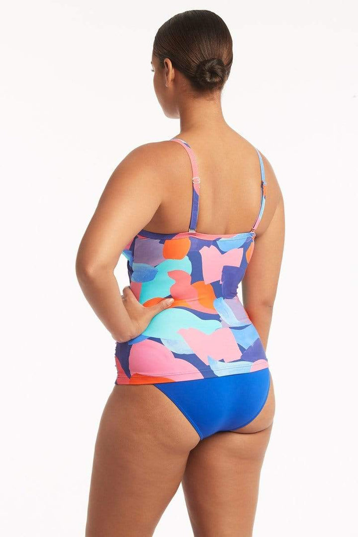 Style # SL3206PB   Sea Level Royal Print Paintball Twist Front Tankini  Escape to a tropical paradise with Sea Level's new paintball print, a hand painted and unexpected take on camouflage in exciting shades of blue, pink and corals. The flattering twist front design hides a comfortable and supportive shelf bra. The mid rise bottom will hug your curves in a beautiful cobalt blue. 