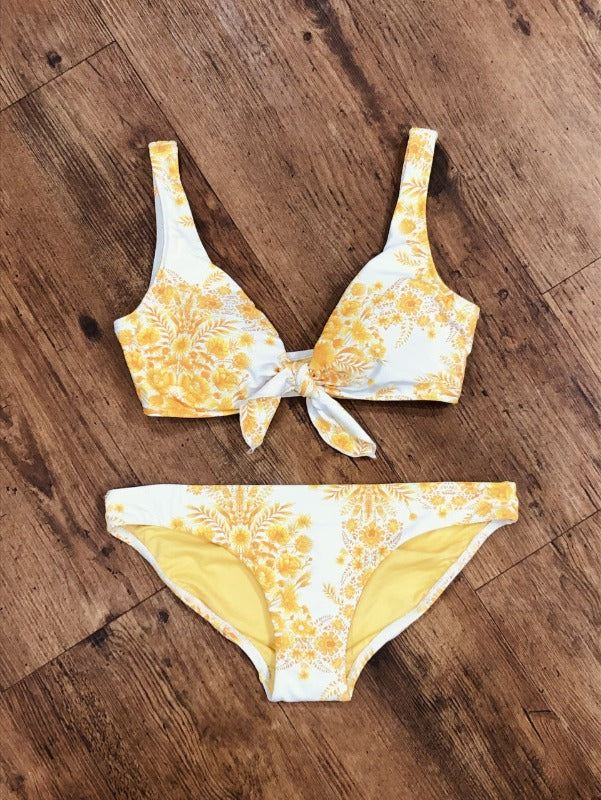 Be the best dressed beach babe this summer in this Sunflower Tie Front Bikini! A unique V-neckline is accompanied by removable soft cups and a sports band for maximum support, perfect for C-cups and up. The hipster bottoms provide medium coverage, and the vibrant sunflower pattern is the perfect way to stand out from the crowd!    31105410/4005441